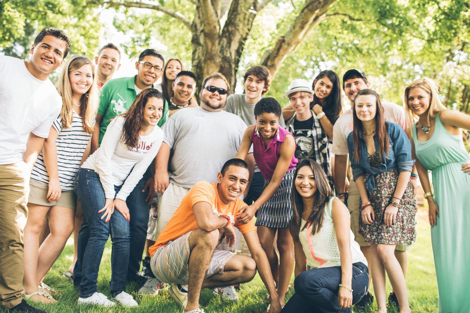 Students posing for group photo beneath a tree.